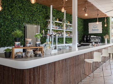 a bar with a white counter and a white chair