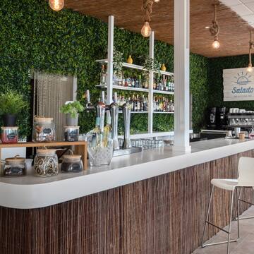 a bar with a white counter and a white chair