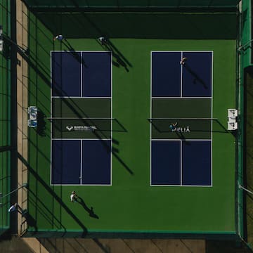 a tennis court with people playing tennis