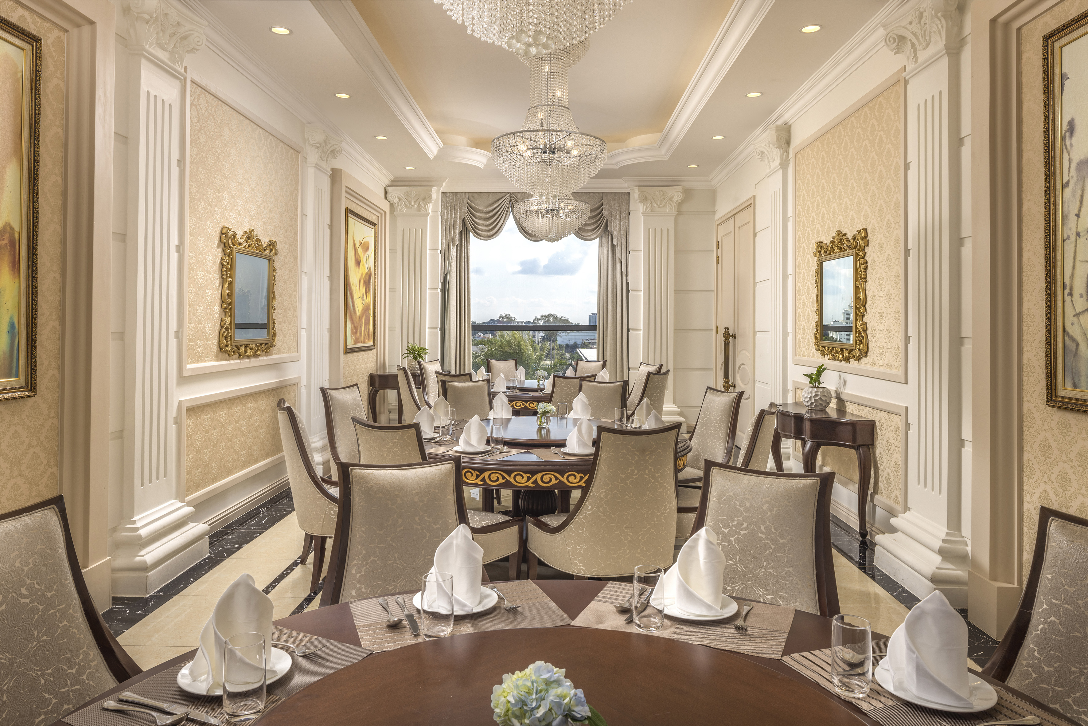 Elegant dining room with chandeliers, ornate decor, and formal table settings.