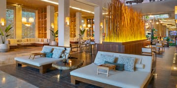 a room with a large white couches and tables