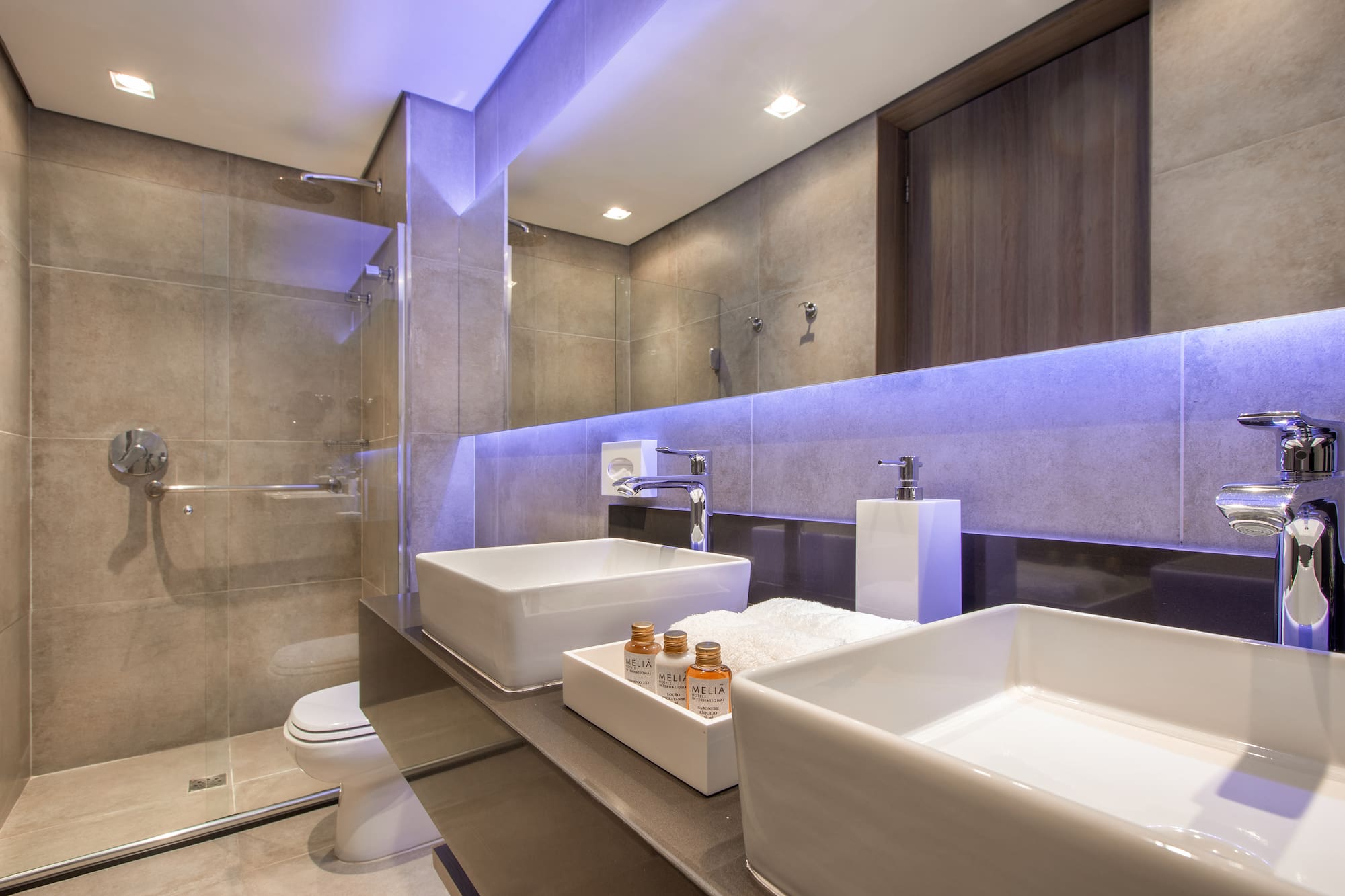 a bathroom with a glass shower and two sinks