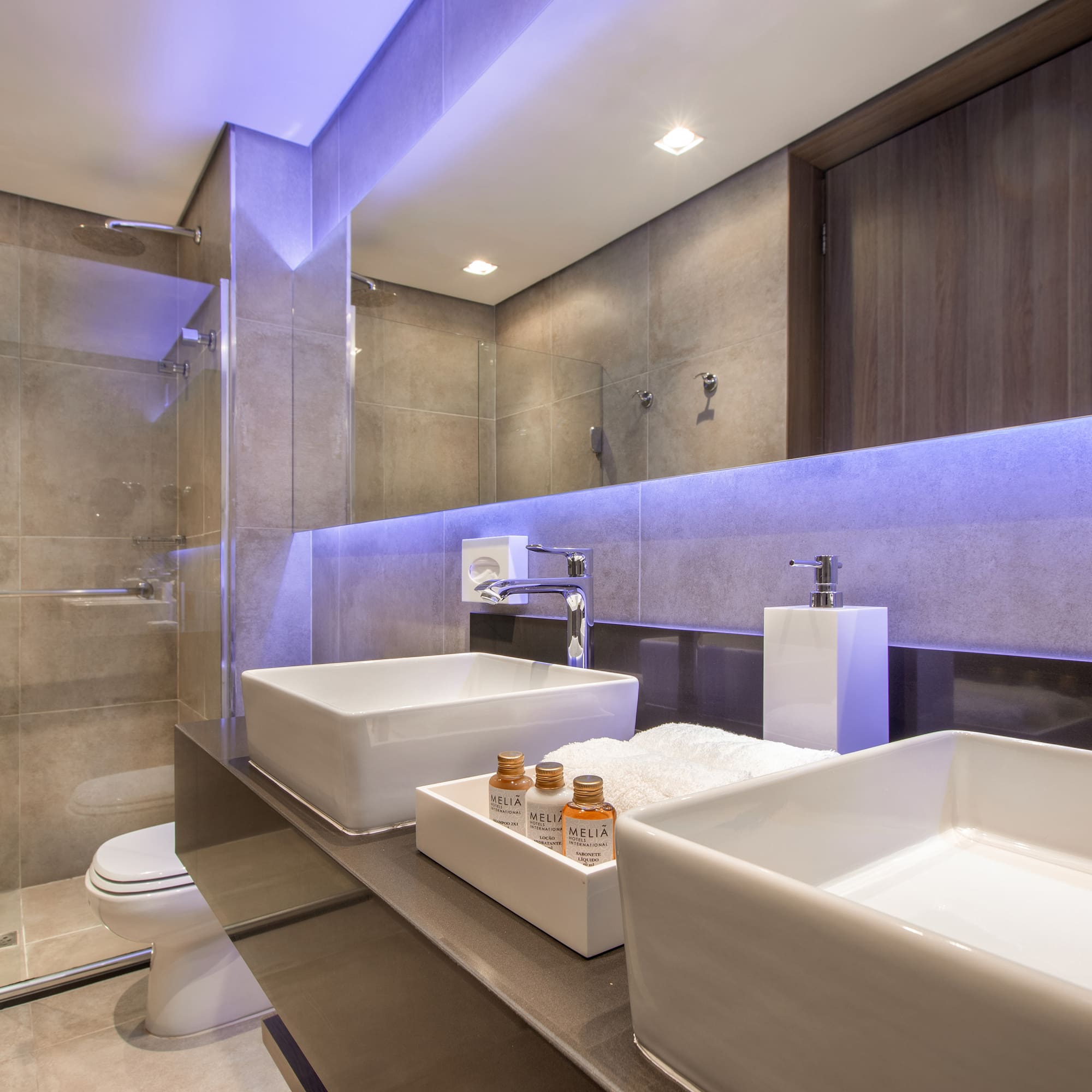 a bathroom with a glass shower and two sinks