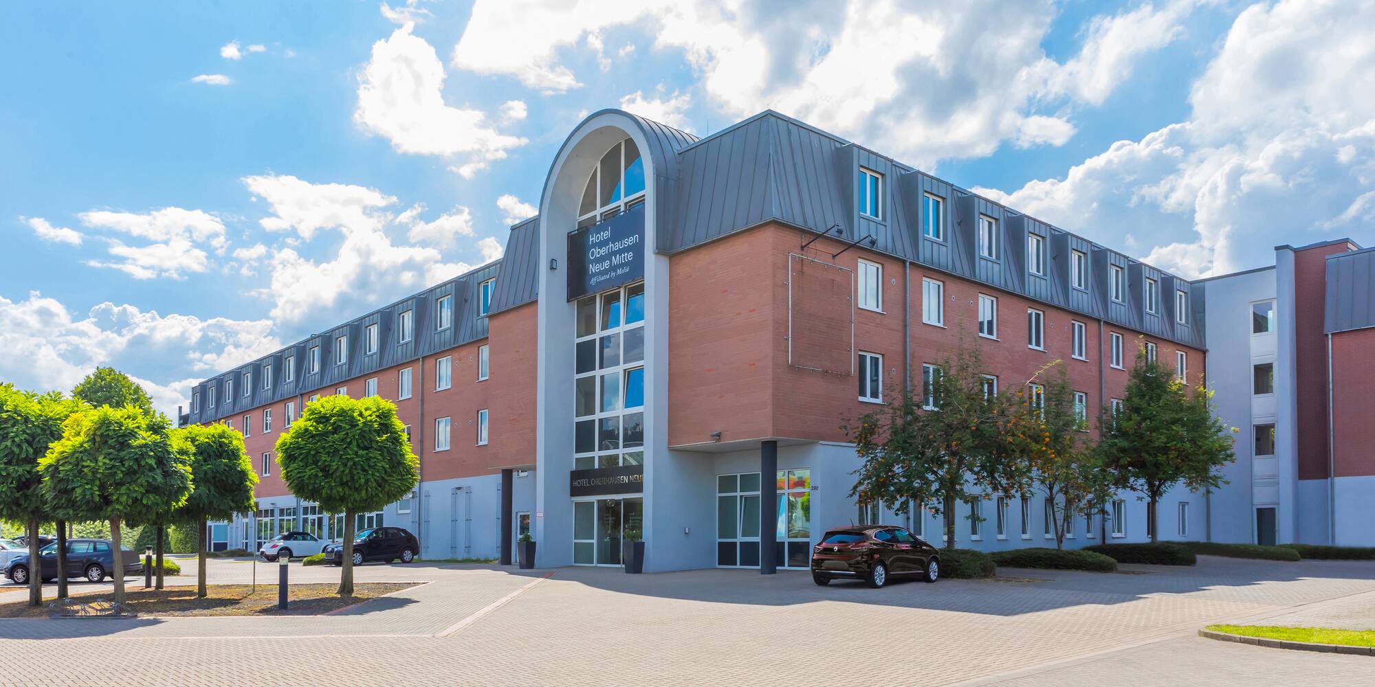 a building with trees and cars in front of it