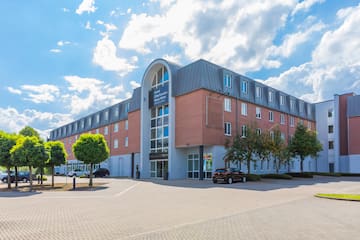 a building with trees and cars in front of it