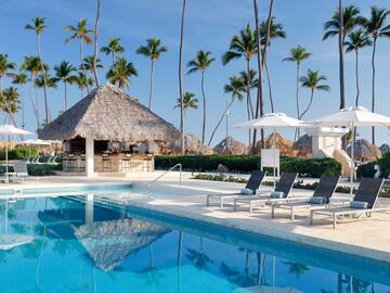 a pool with chairs and umbrellas by a bar