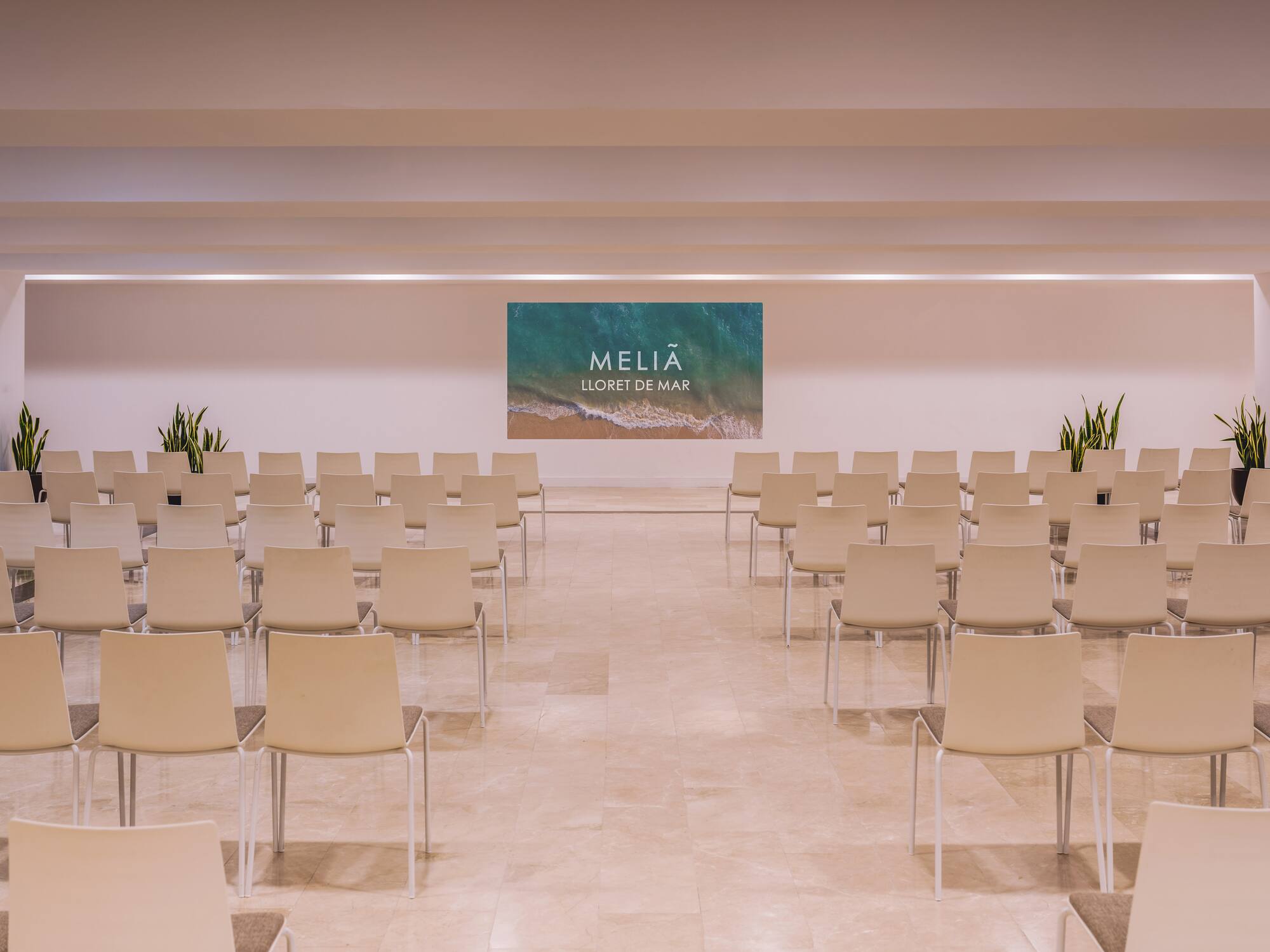 Melia Lloret de Mar conference room with chairs and branded screen.