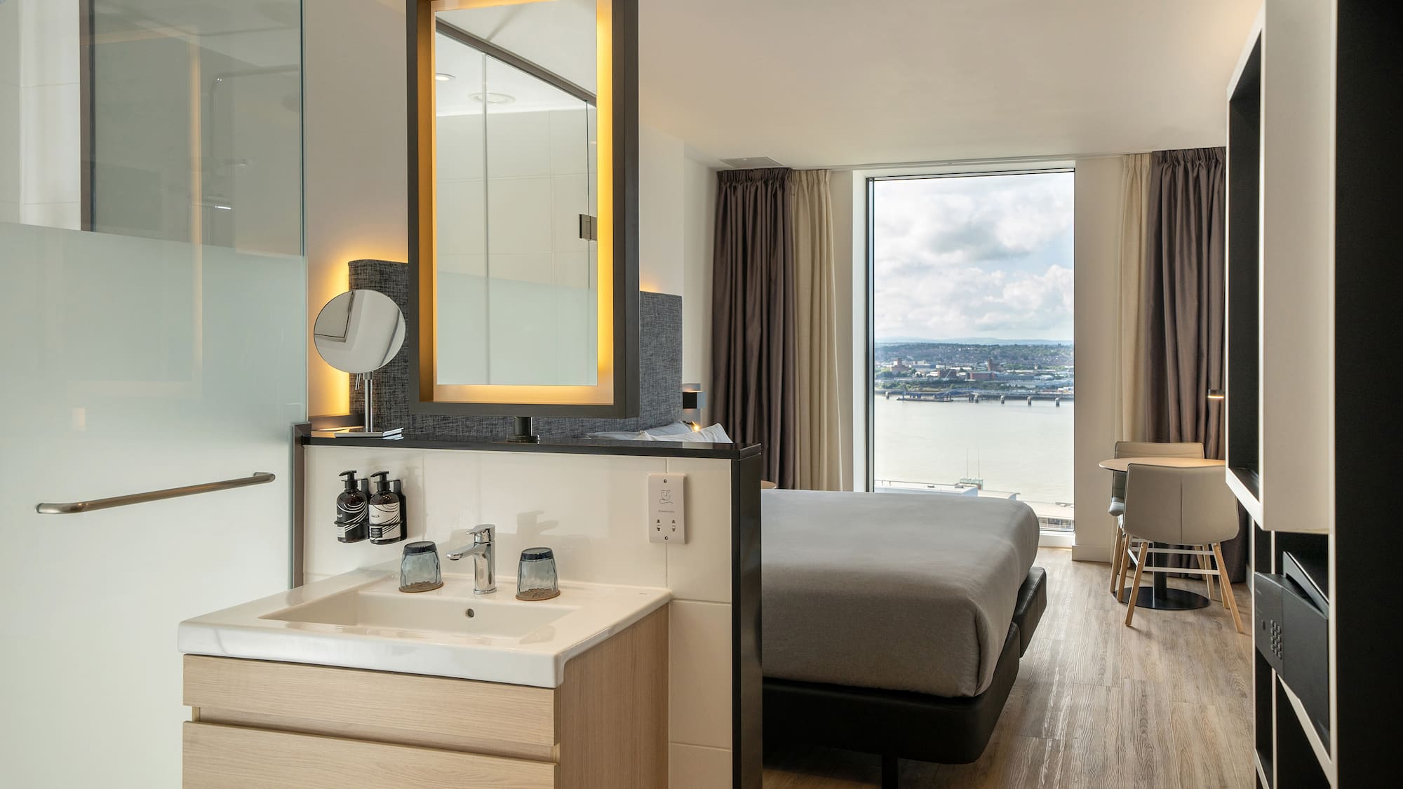 a room with a bed and sink and a mirror