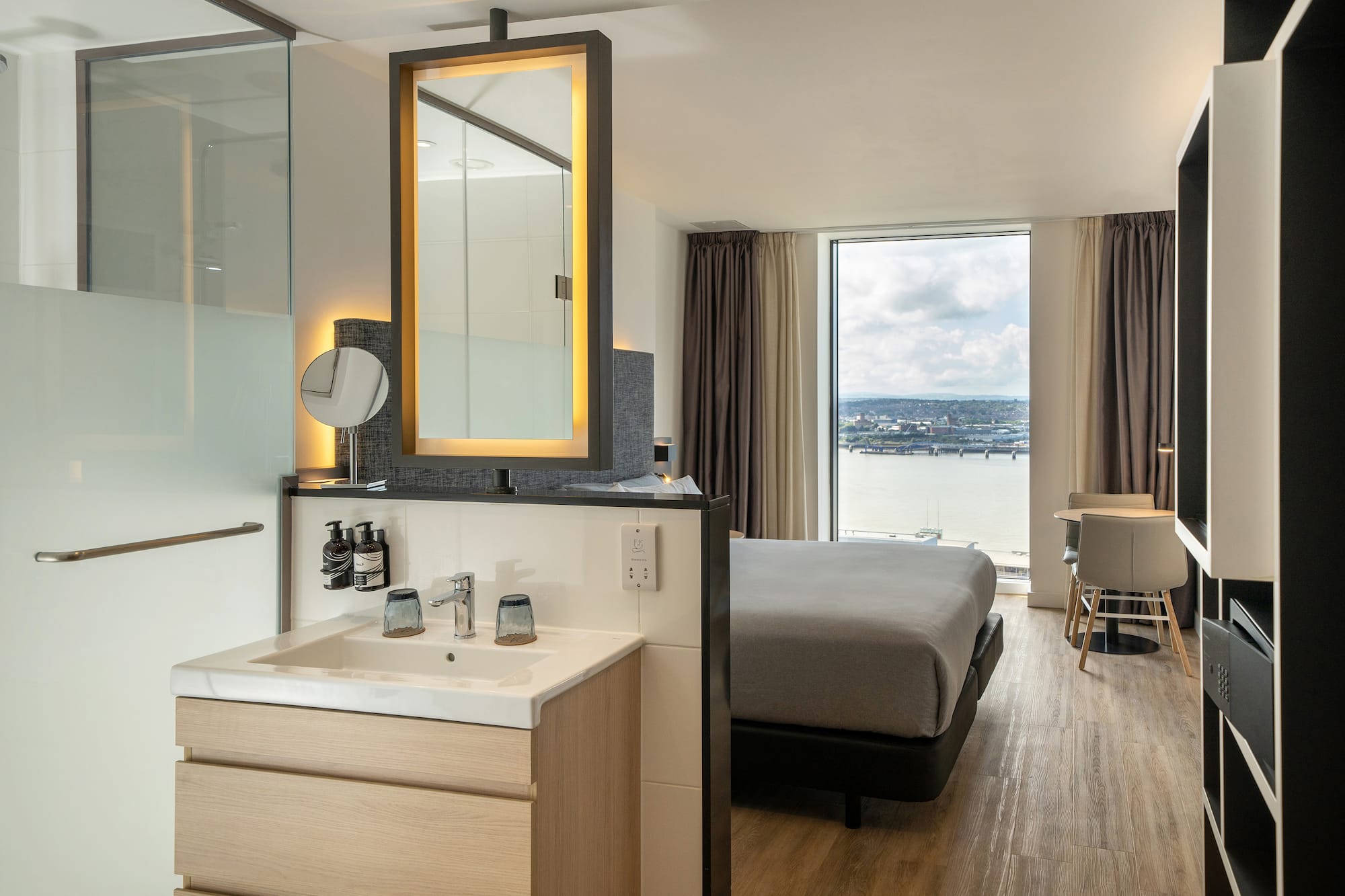 a room with a bed and sink and a mirror