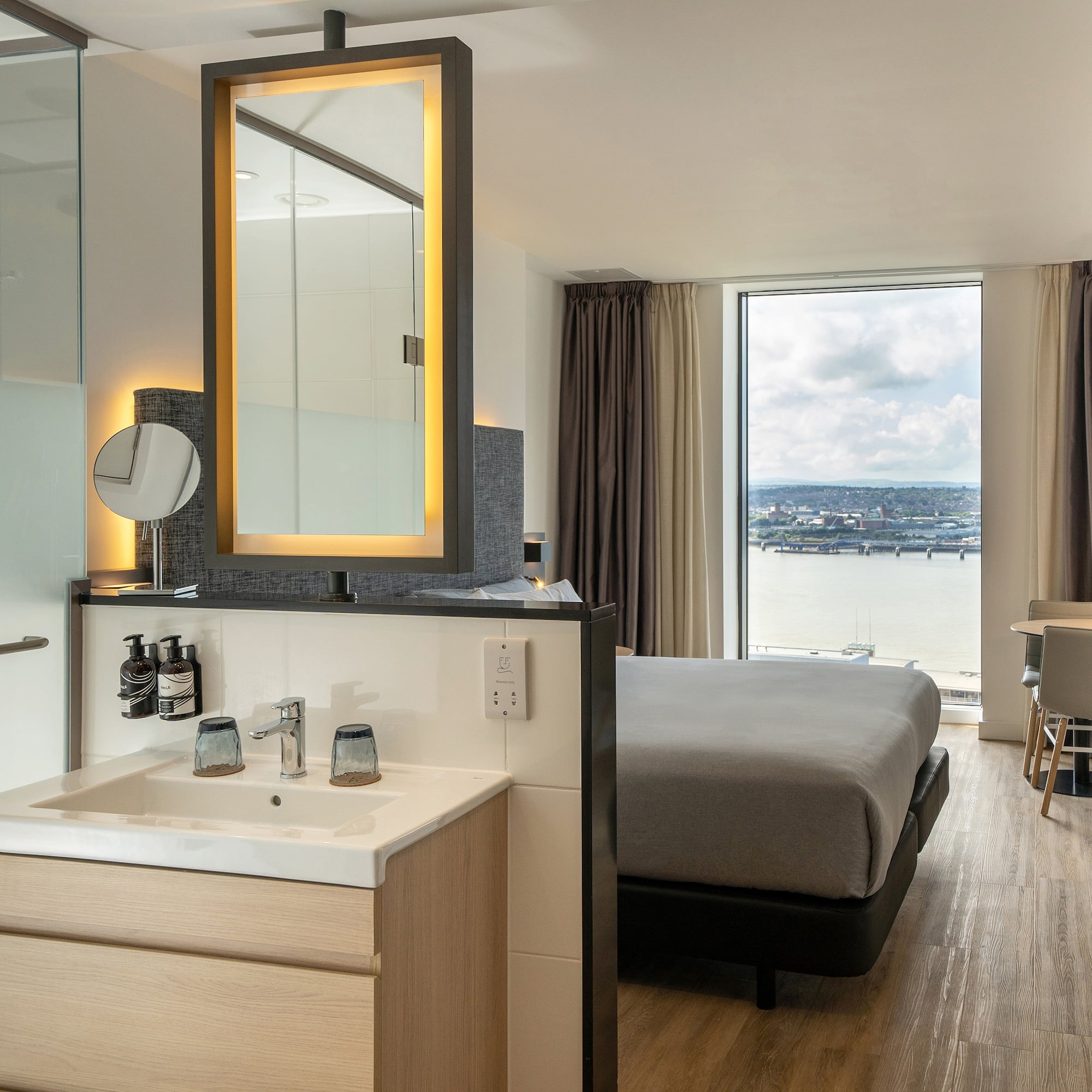 a room with a bed and sink and a mirror