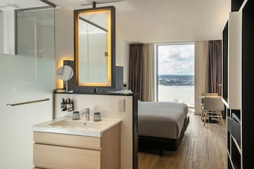 a room with a bed and sink and a mirror