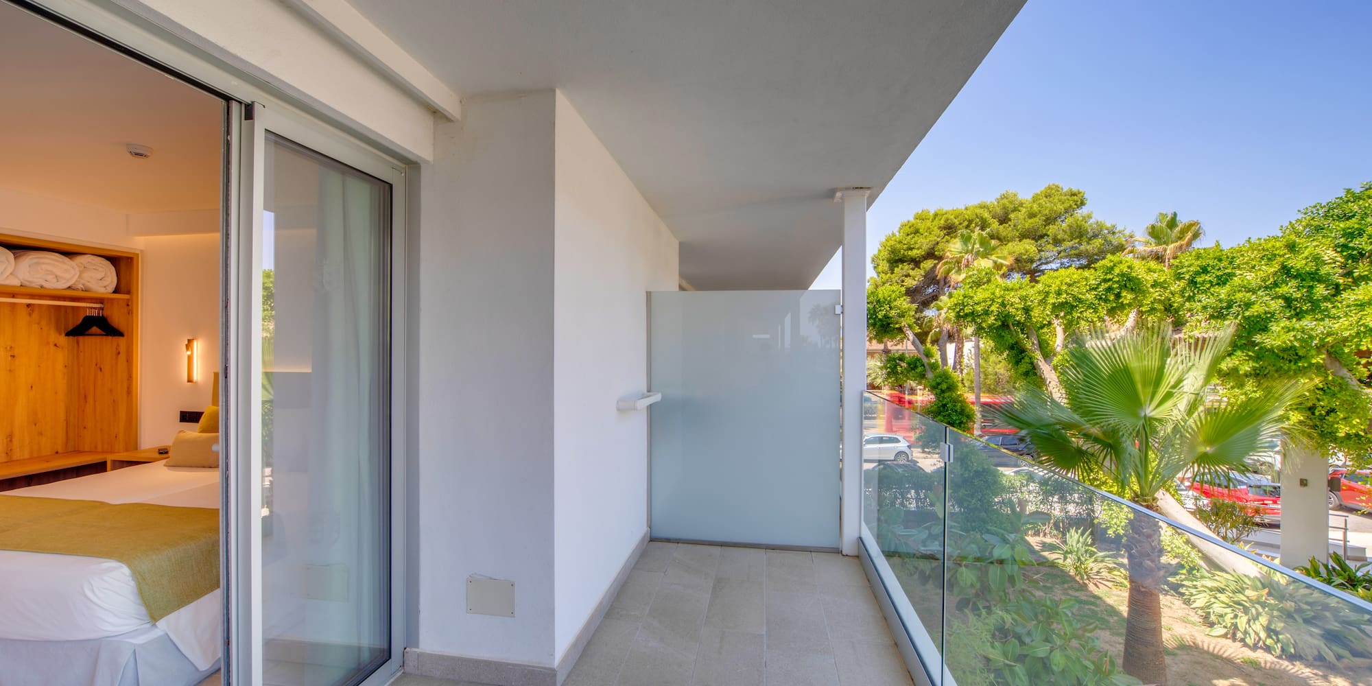 a balcony with glass doors and trees