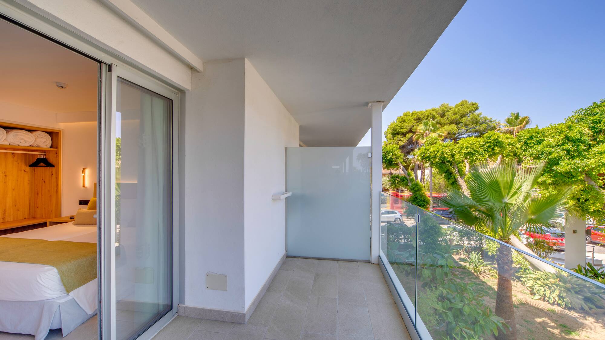 a balcony with glass doors and trees