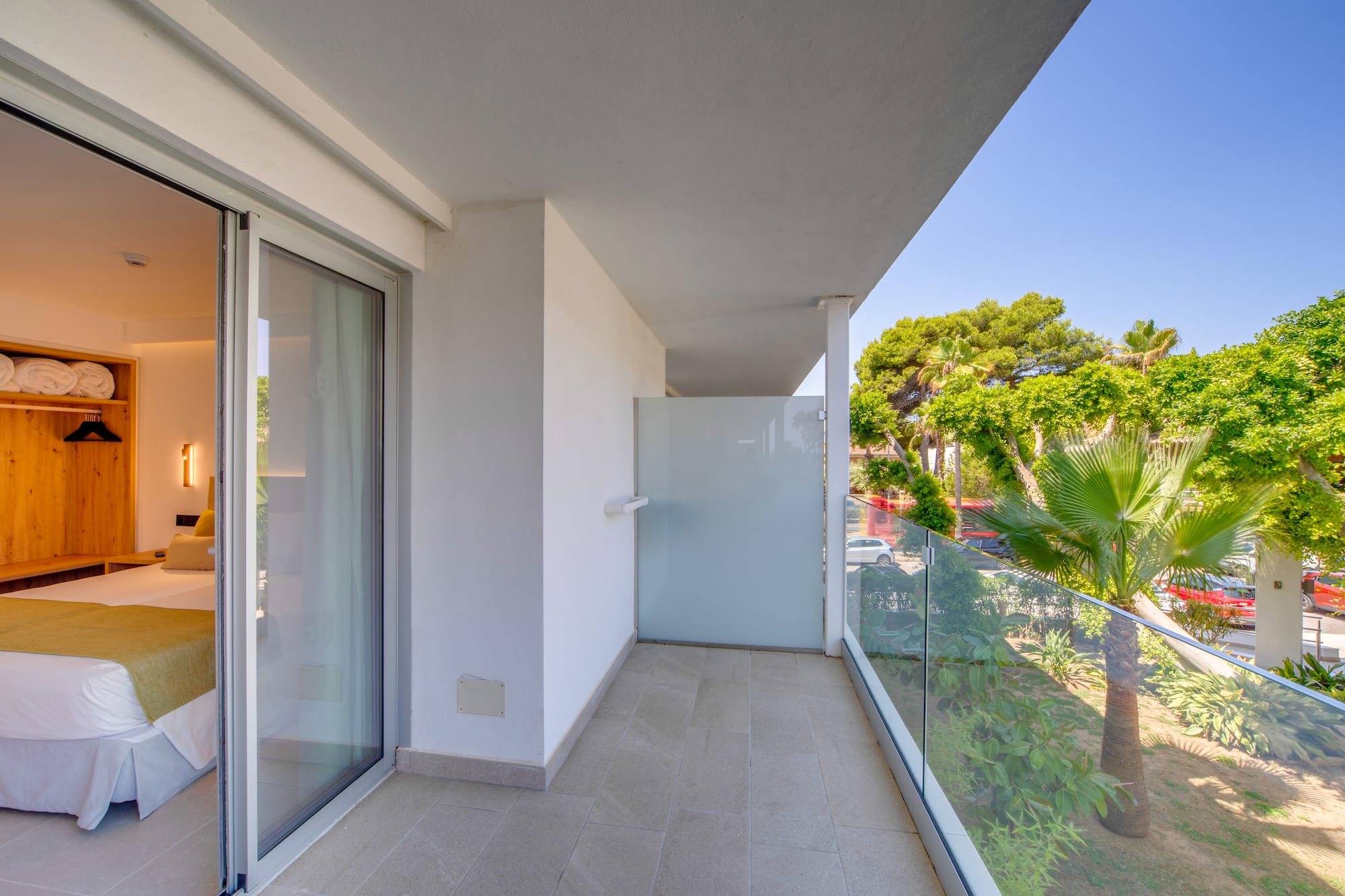 a balcony with glass doors and trees