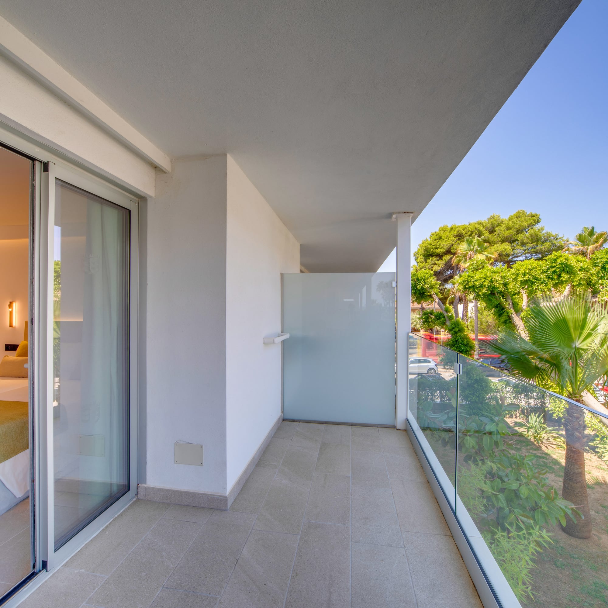 a balcony with glass doors and trees