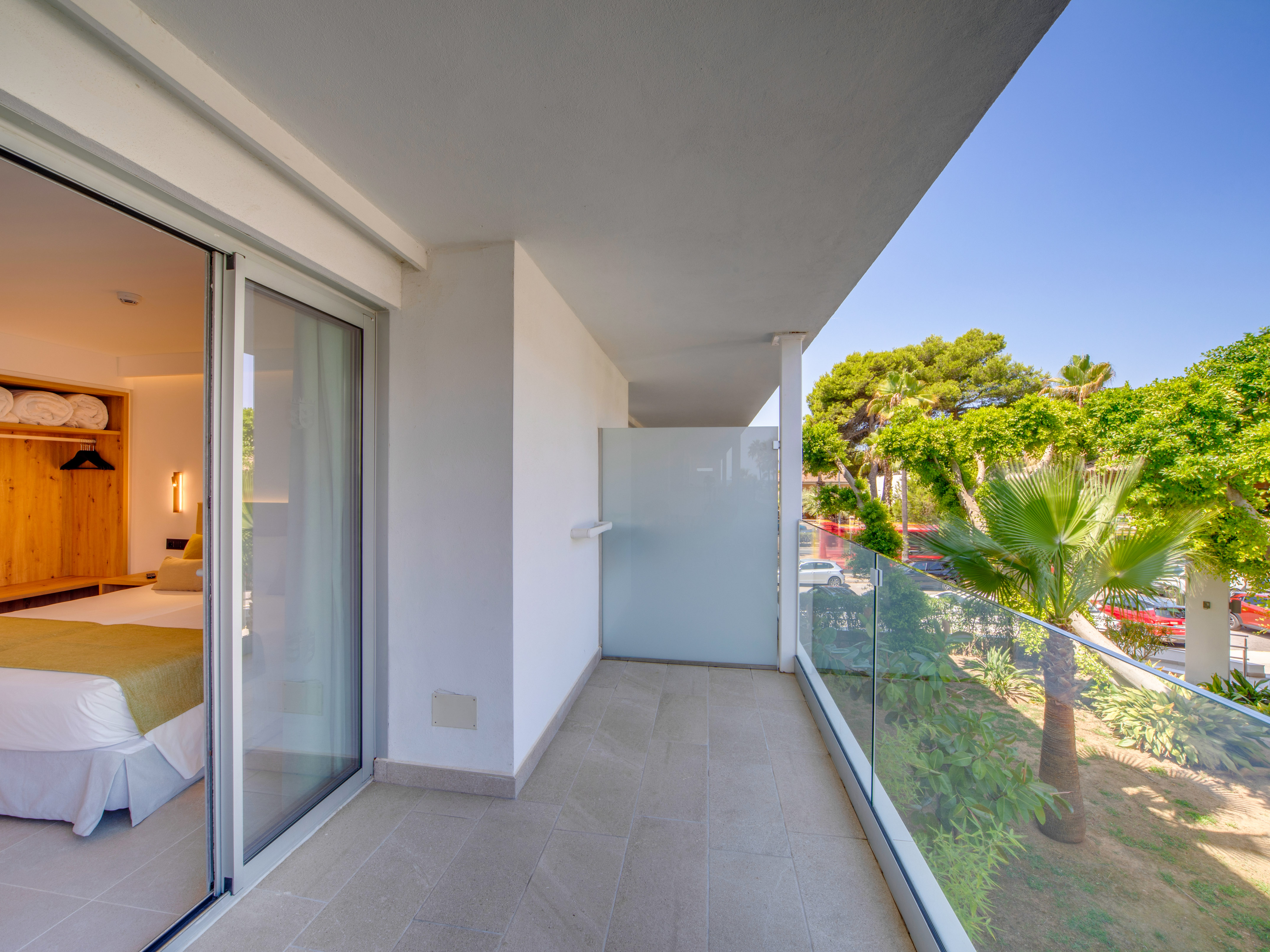 a balcony with glass doors and trees