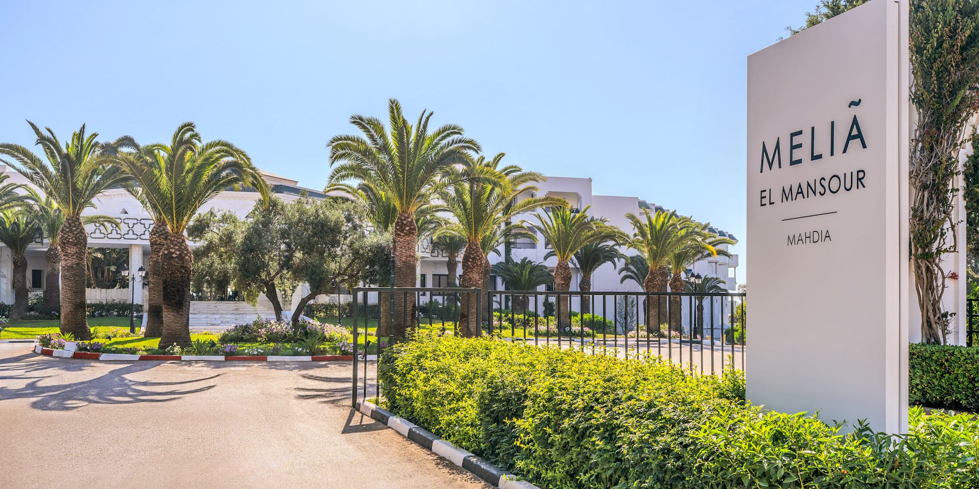 Melia El Mansour Mahdia resort entrance sign and palm trees.