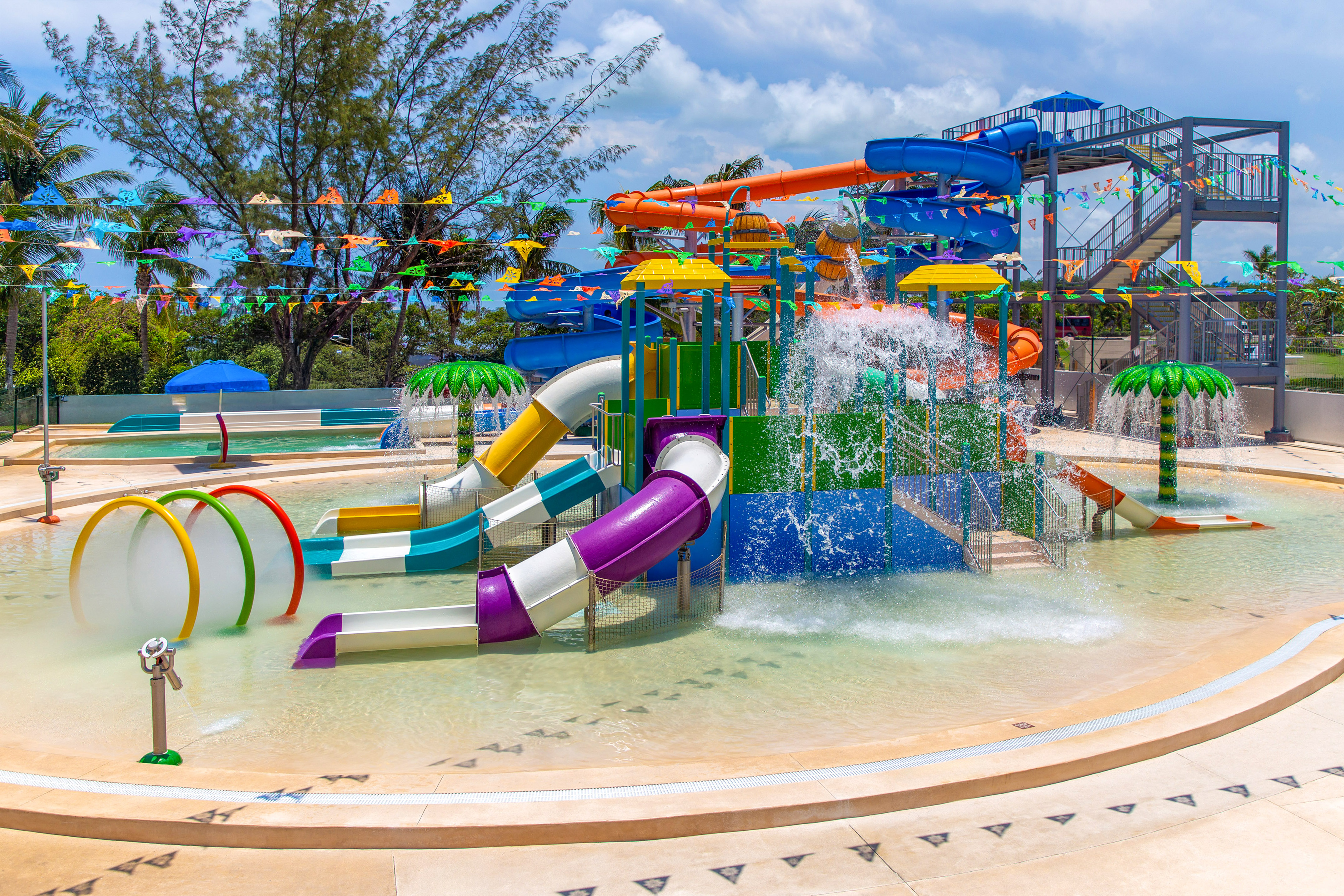 Colorful water park with multiple slides, splash pad, and water play area.