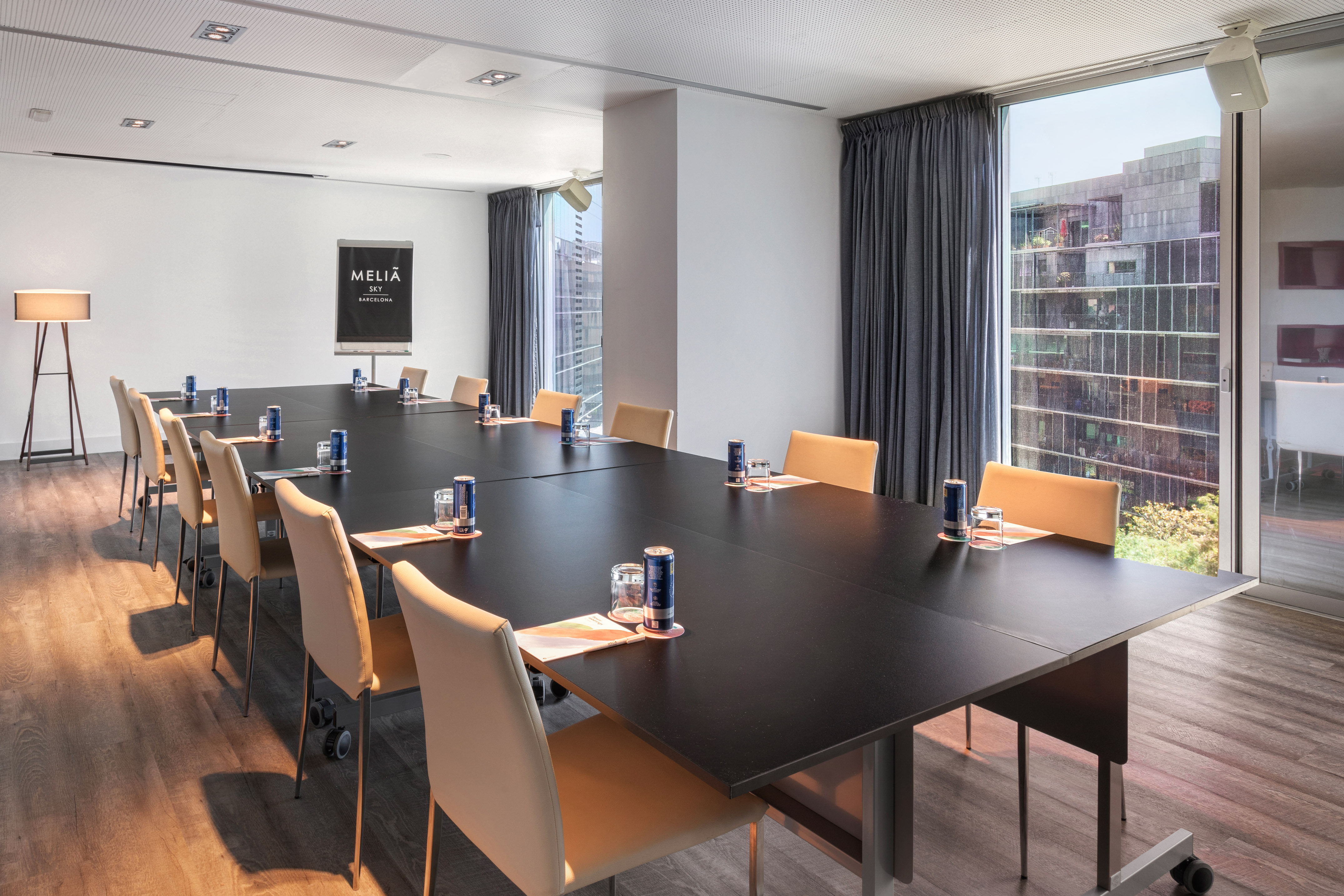 Meliá Sky Barcelona meeting room with dark table, chairs, and city view. - Library - Meliá Barcelona Sky, Barcelona
