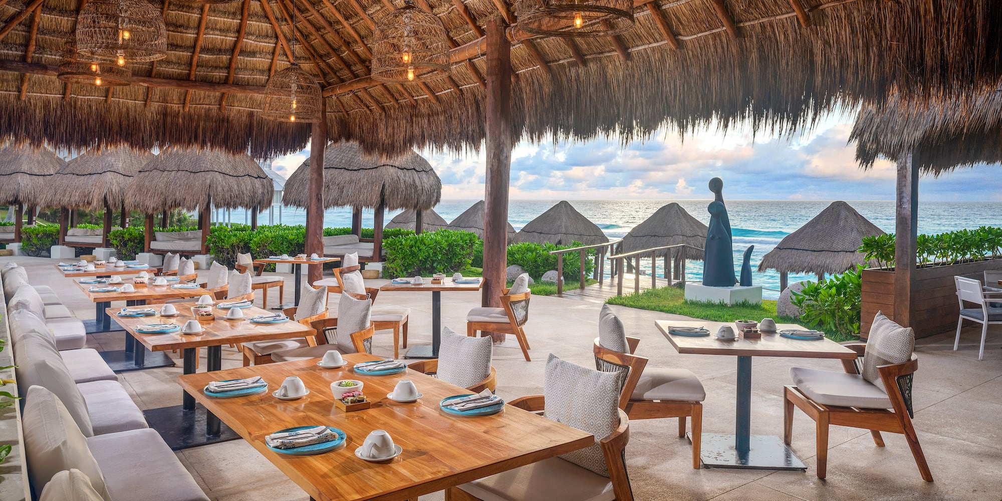 a restaurant with tables and chairs and straw umbrellas