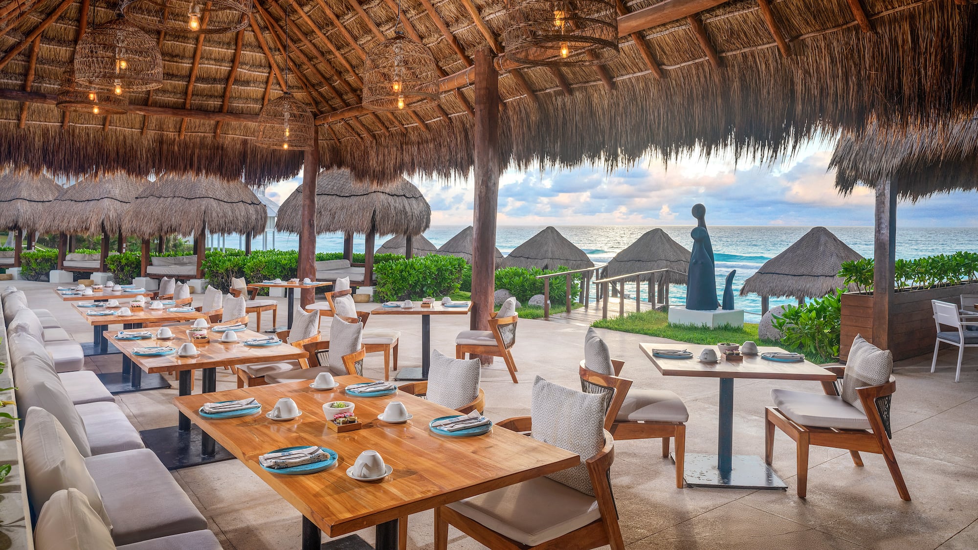 a restaurant with tables and chairs and straw umbrellas