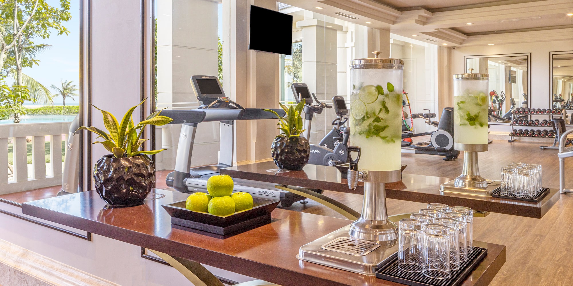 a table with a drink dispenser and fruit on it