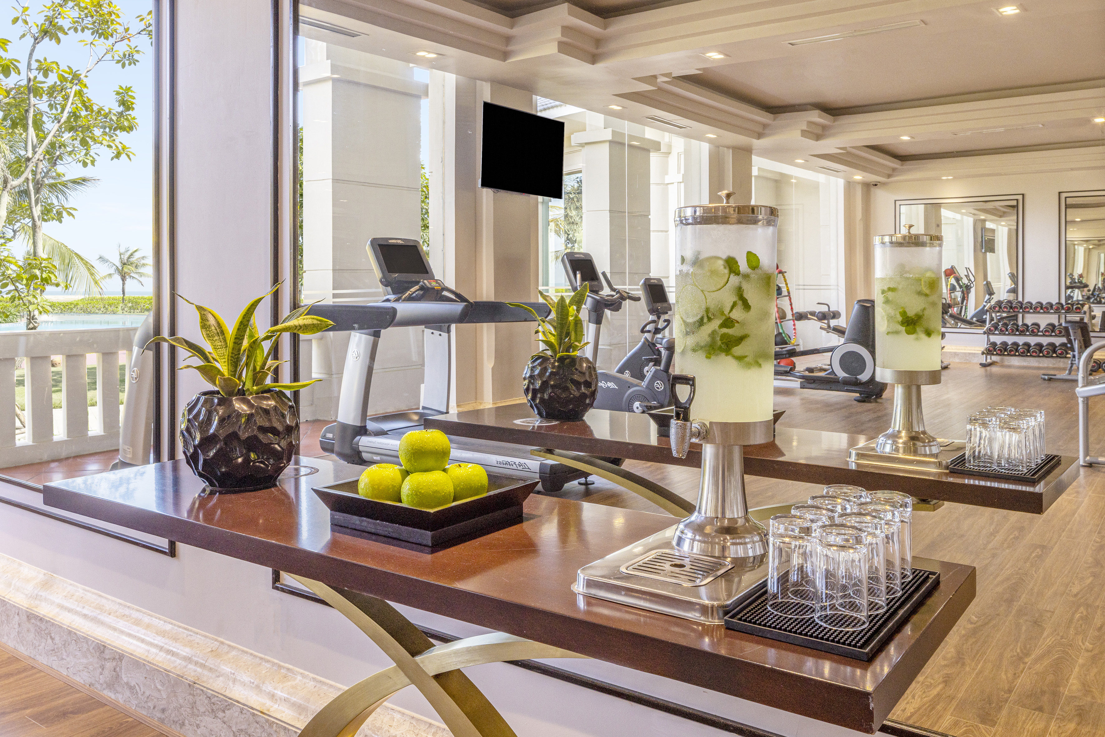 a table with a drink dispenser and fruit on it