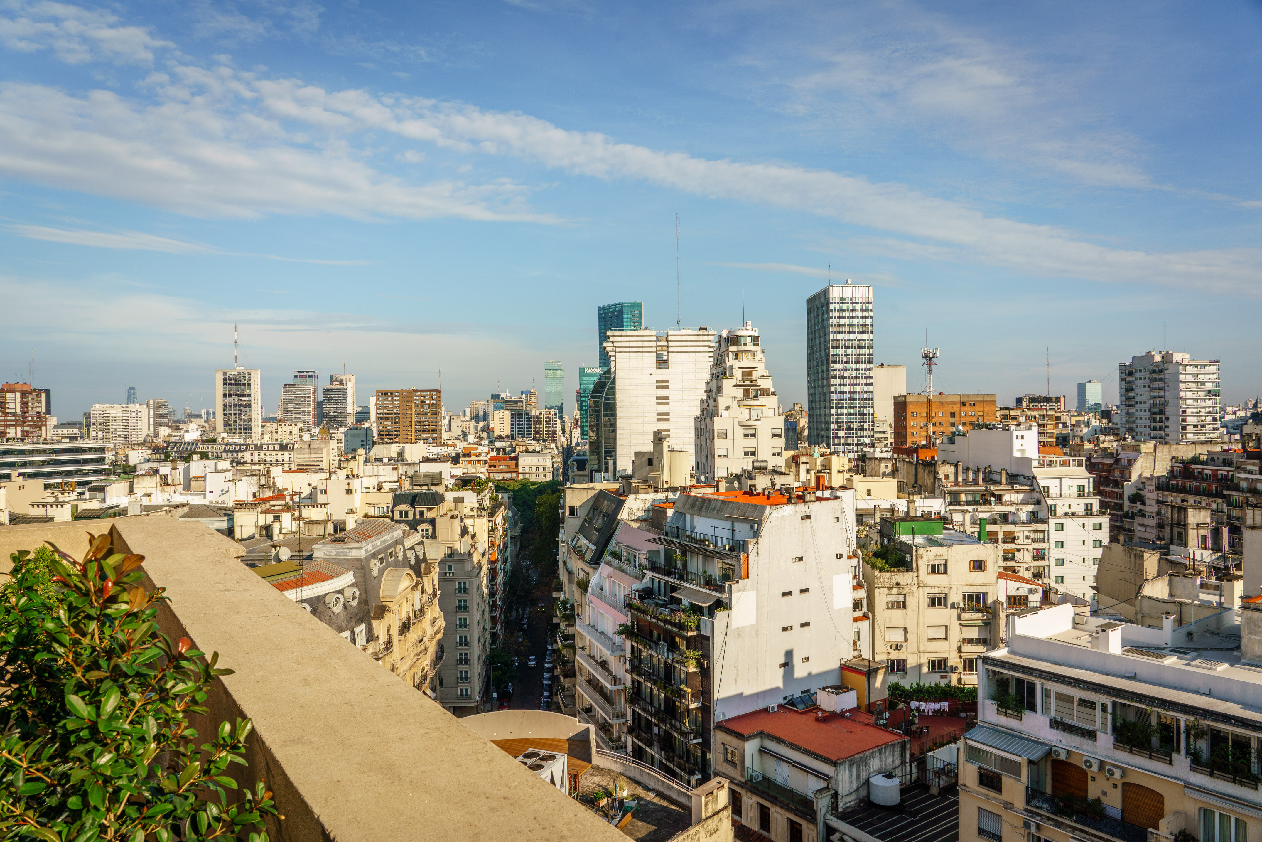 Buenos Aires cityscape: dense buildings, skyscrapers, and a street under blue sky.