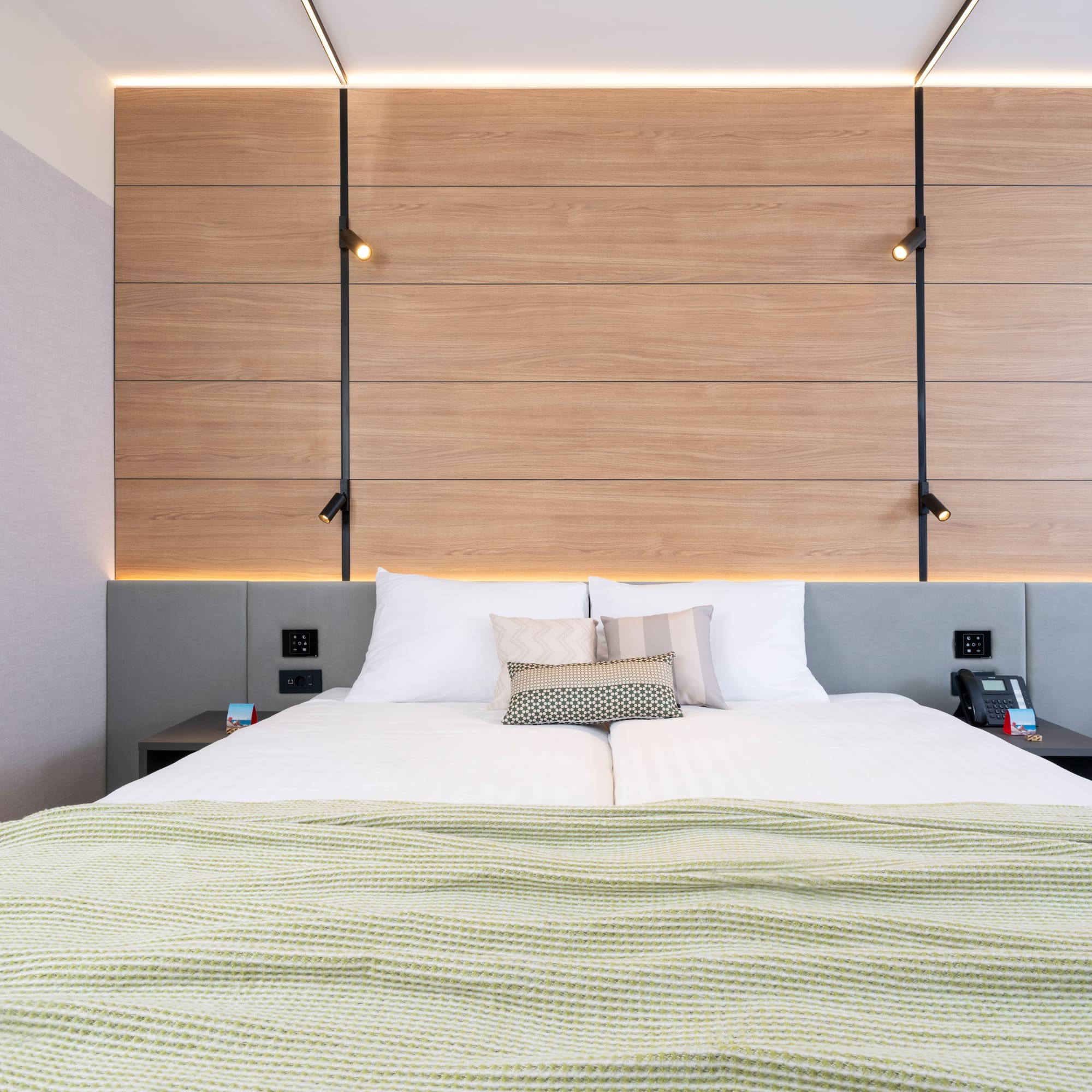 a bed with pillows and a wood paneled wall