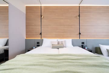 a bed with pillows and a wood paneled wall