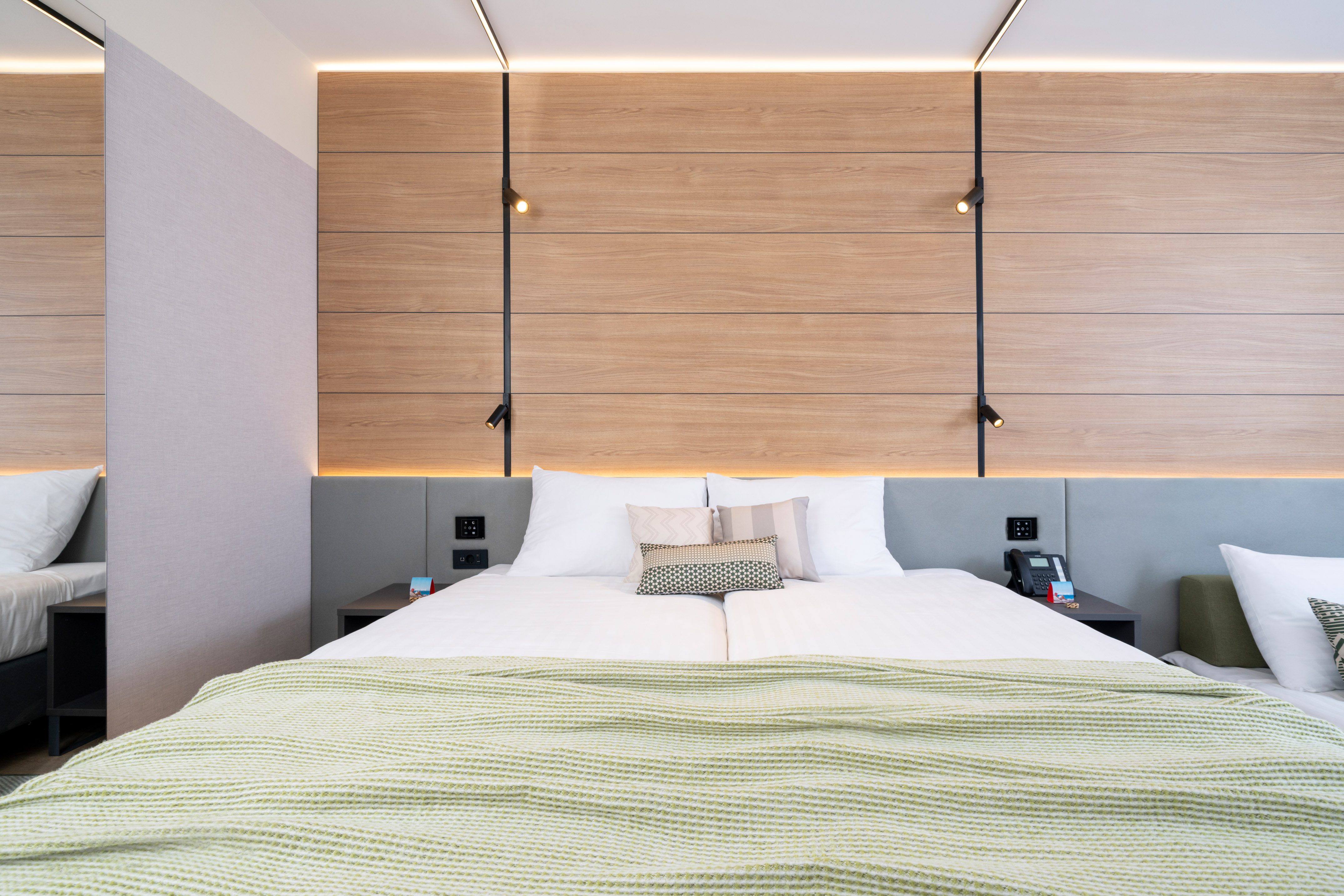 a bed with pillows and a wood paneled wall