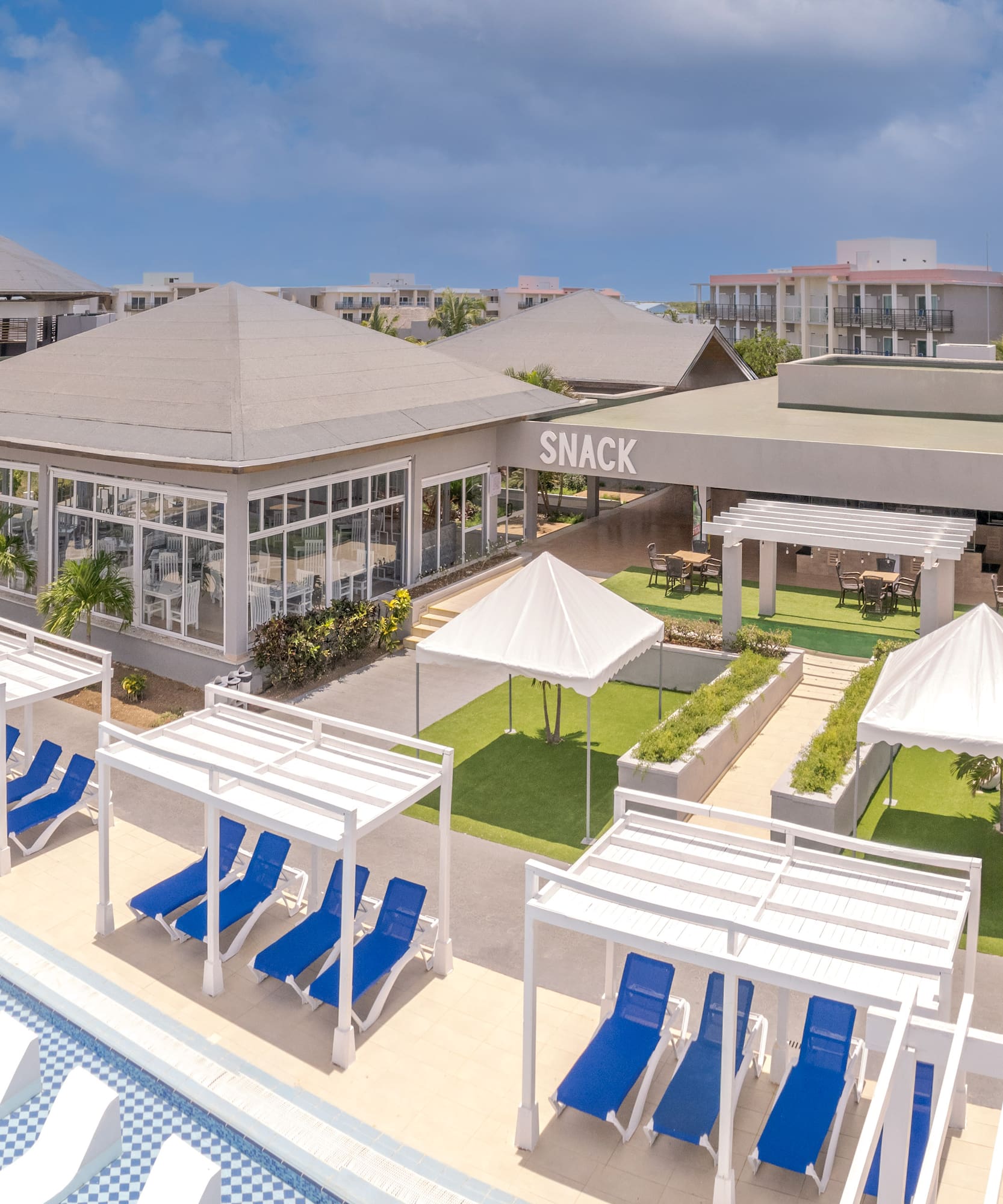 a pool with lounge chairs and a building with a pool