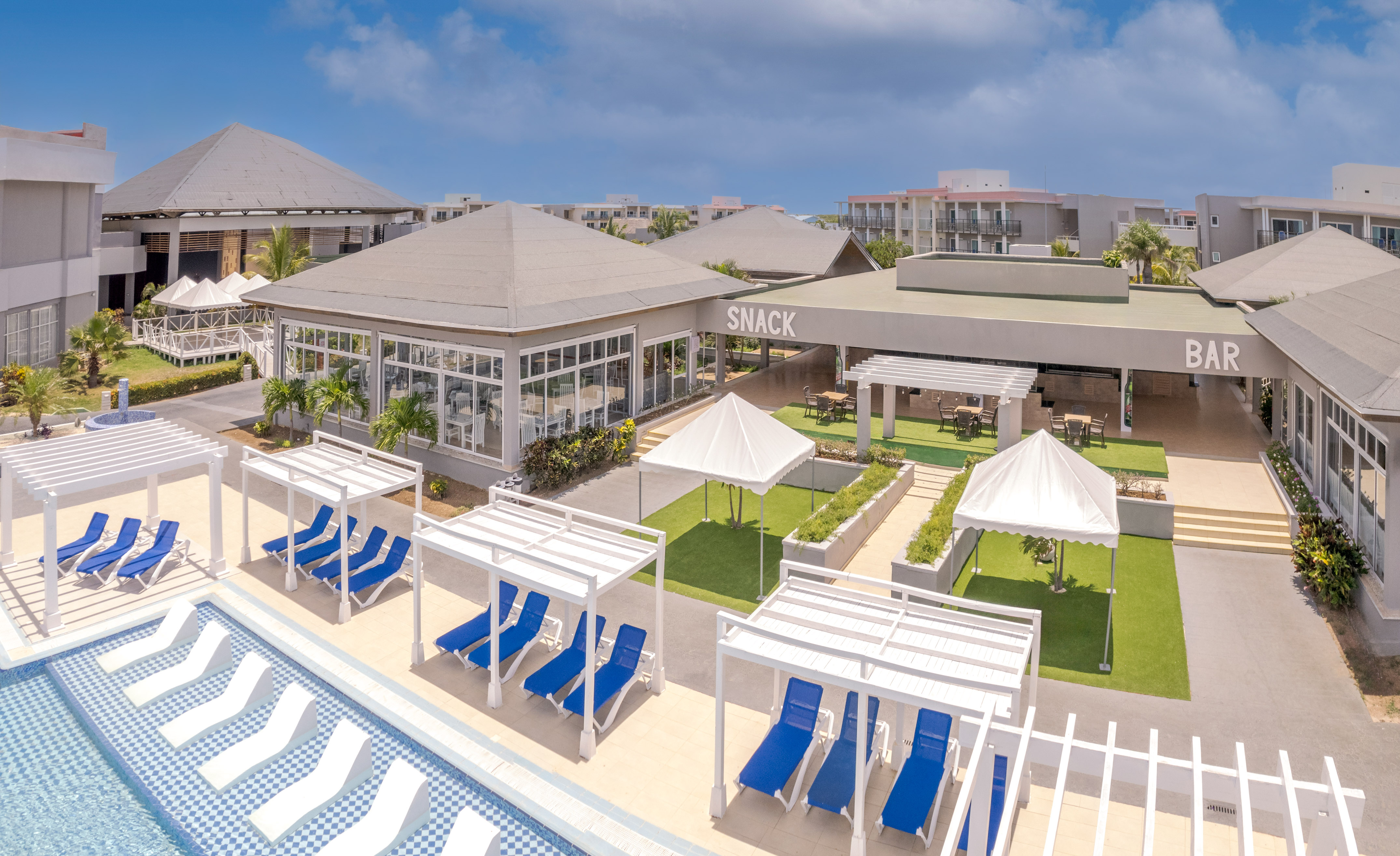 a pool with lounge chairs and a building with a pool