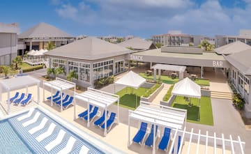 a pool with lounge chairs and a building with a pool