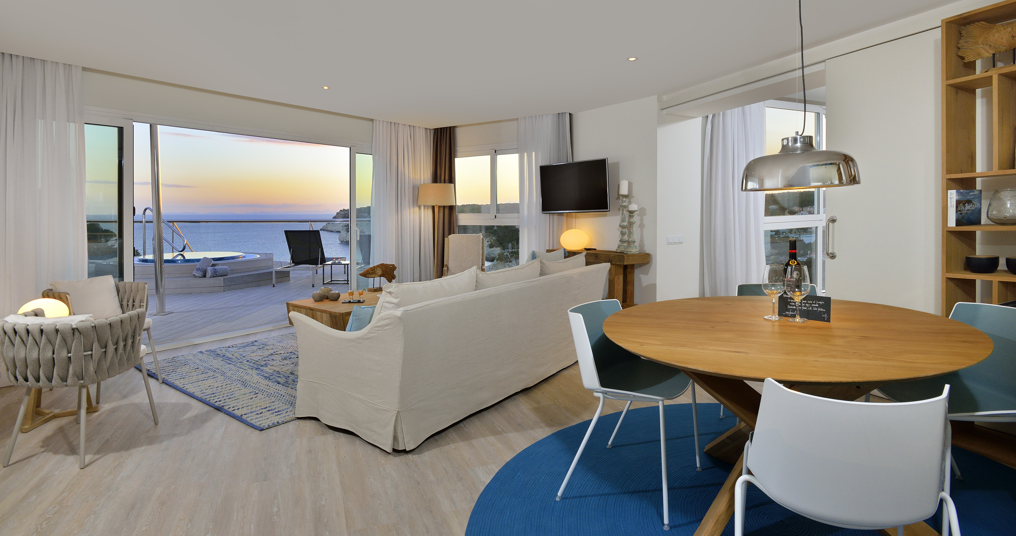 Luxury oceanfront apartment with sunset view, terrace hot tub, living & dining.