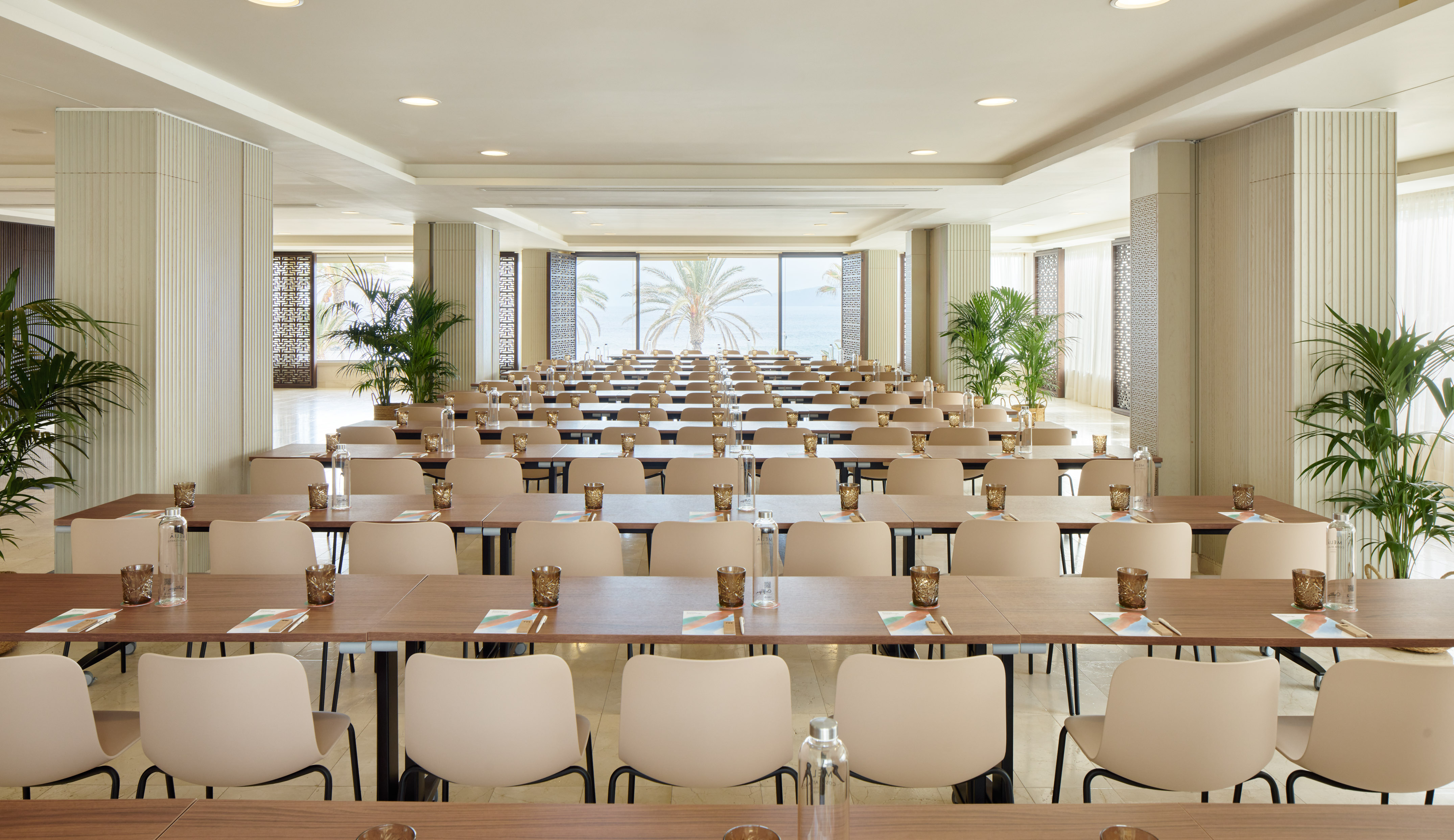 Modern conference room, classroom setup, ocean view, palm trees.
