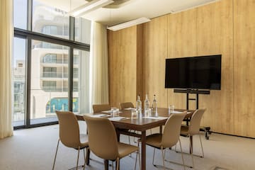 a room with a table and chairs and a television