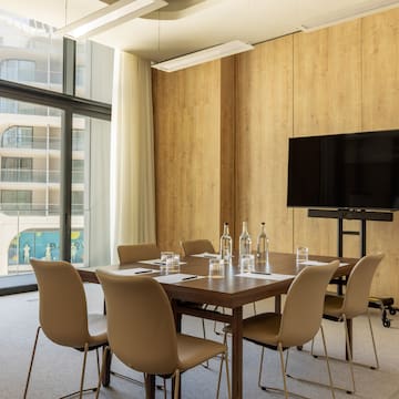 a room with a table and chairs and a television