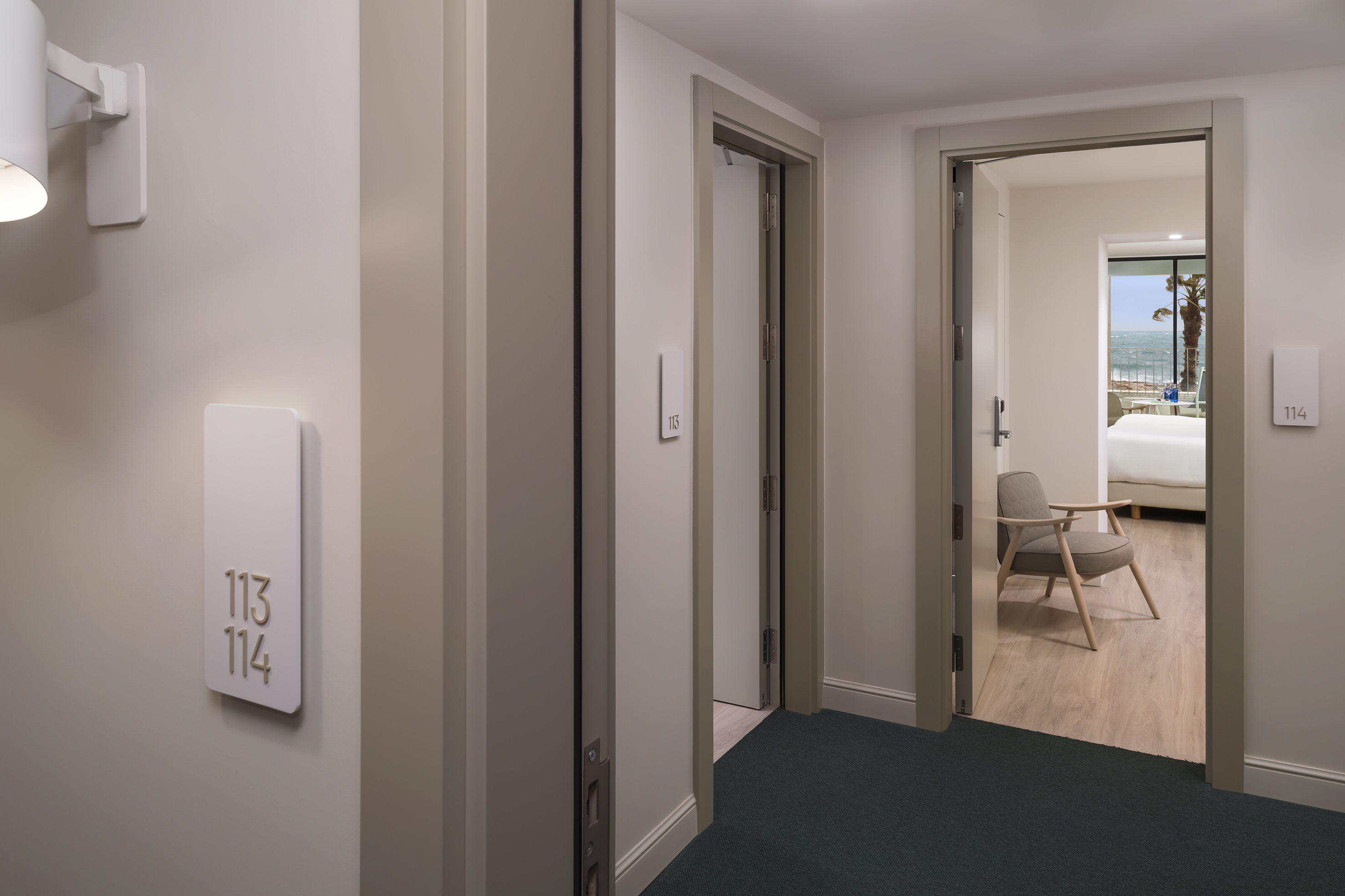 Modern hotel hallway to room 114 showing ocean and beach view.