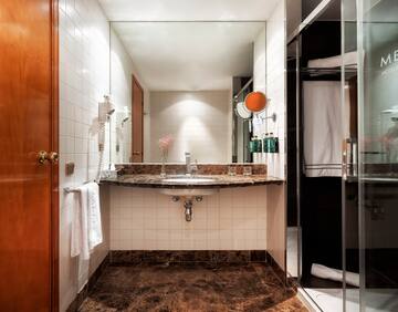 a bathroom with a marble countertop sink and shower