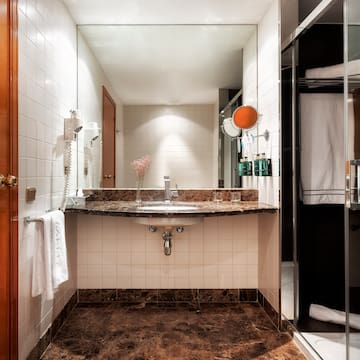 a bathroom with a marble countertop sink and shower