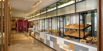 a food buffet with a variety of breads on shelves