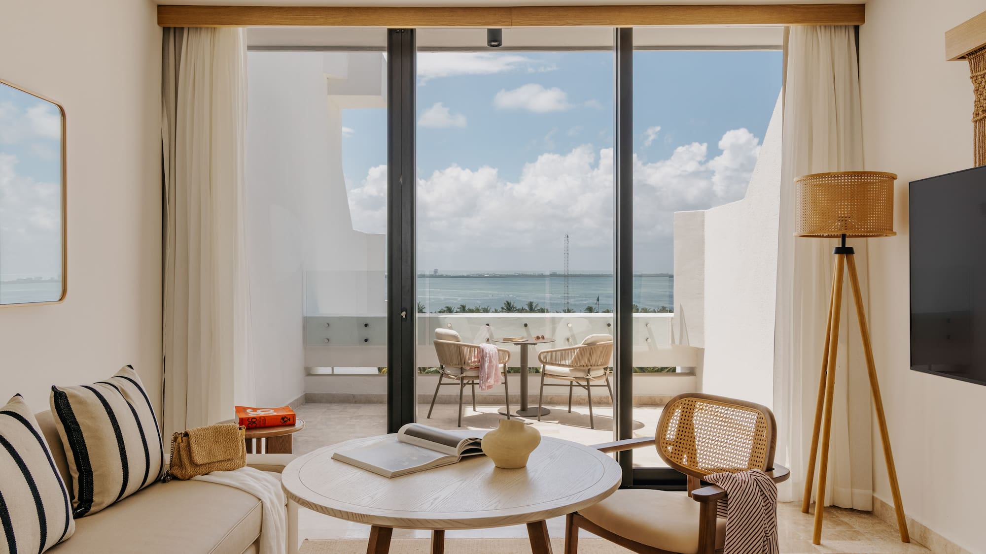 Coastal hotel suite with ocean view balcony and modern living area.