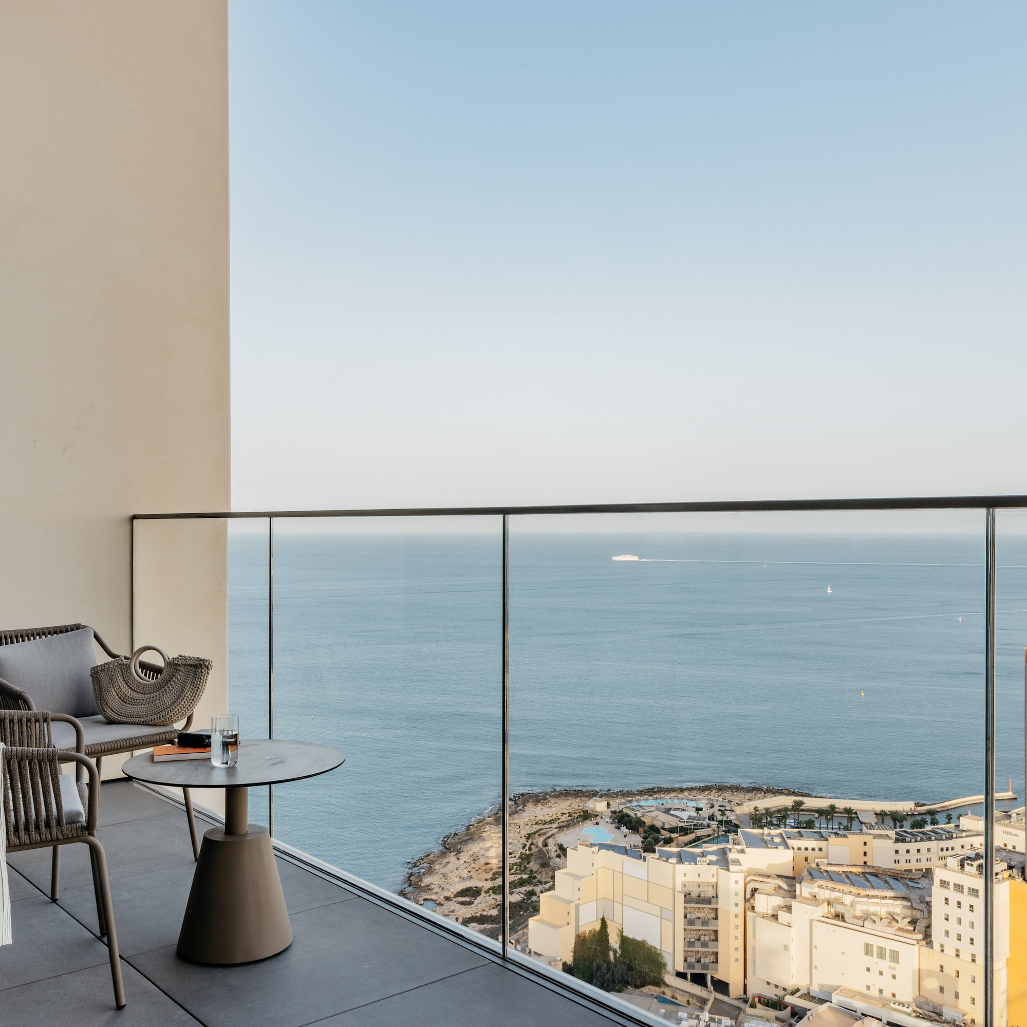 a balcony with a view of the ocean and a city