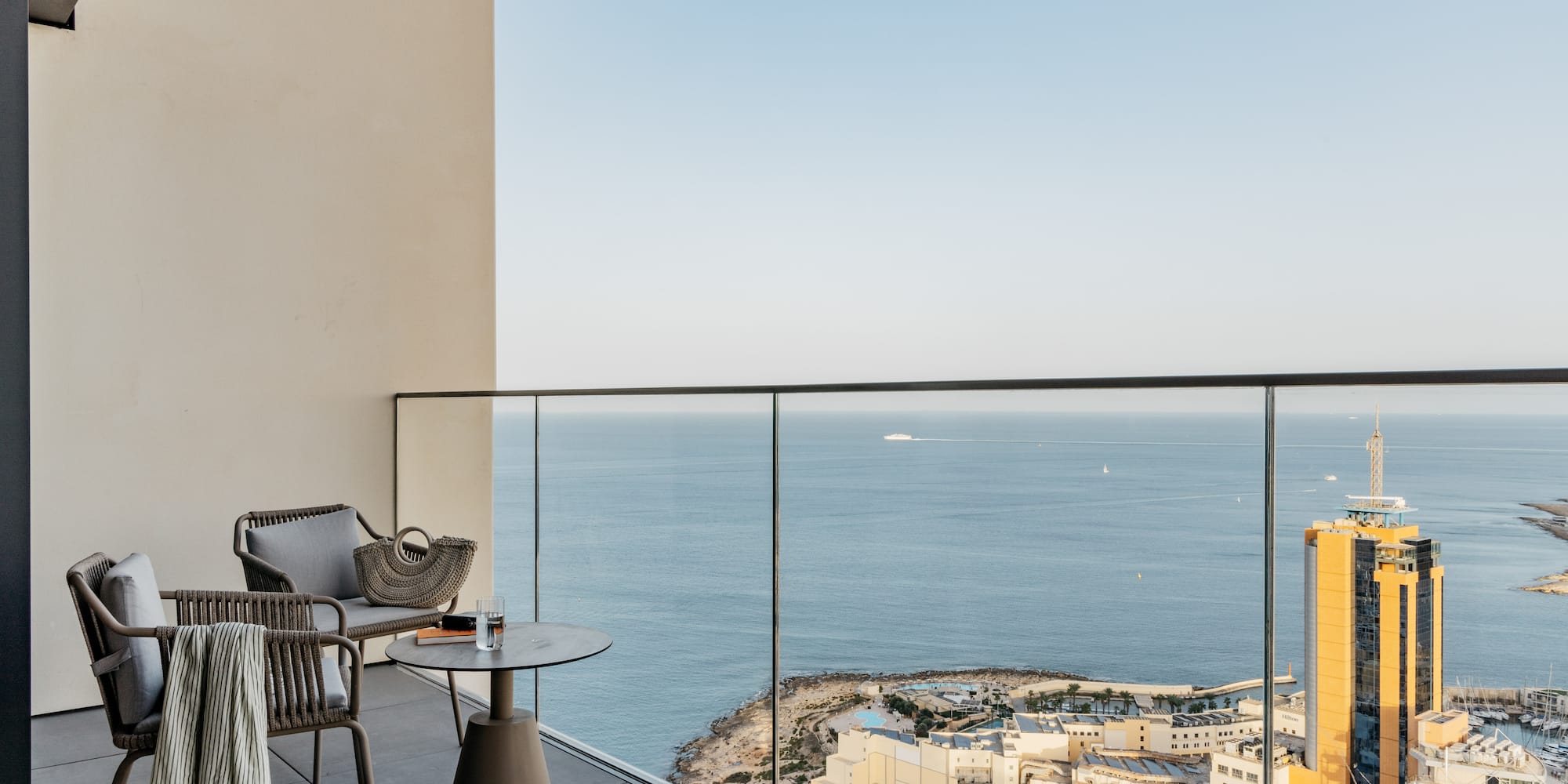 a balcony with a view of the ocean and a city
