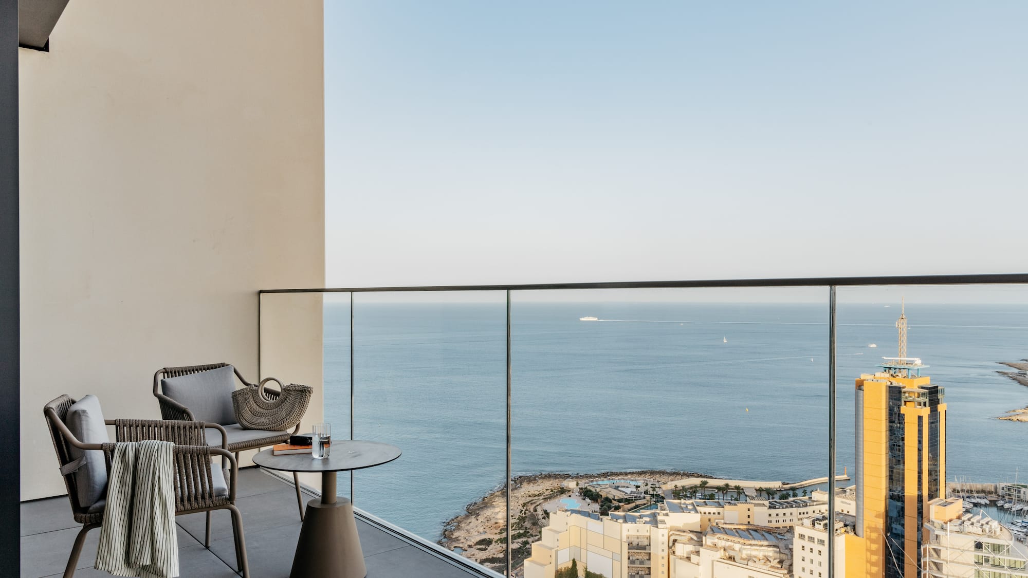 a balcony with a view of the ocean and a city