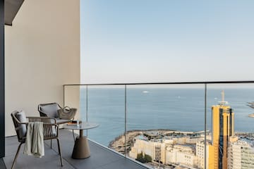 a balcony with a view of the ocean and a city