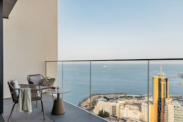 a balcony with a view of the ocean and a city