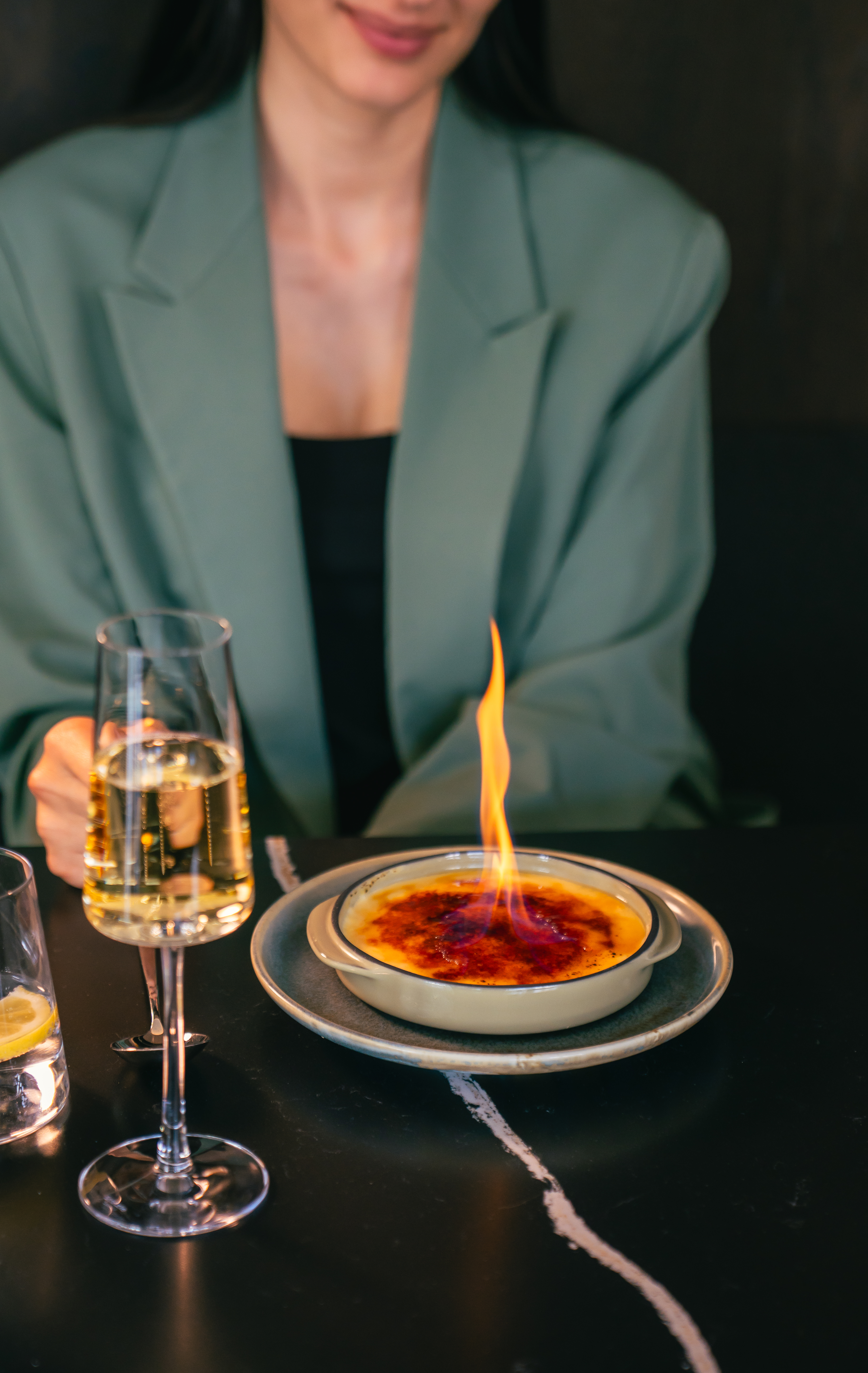 a person holding a glass of wine and a plate with food on it