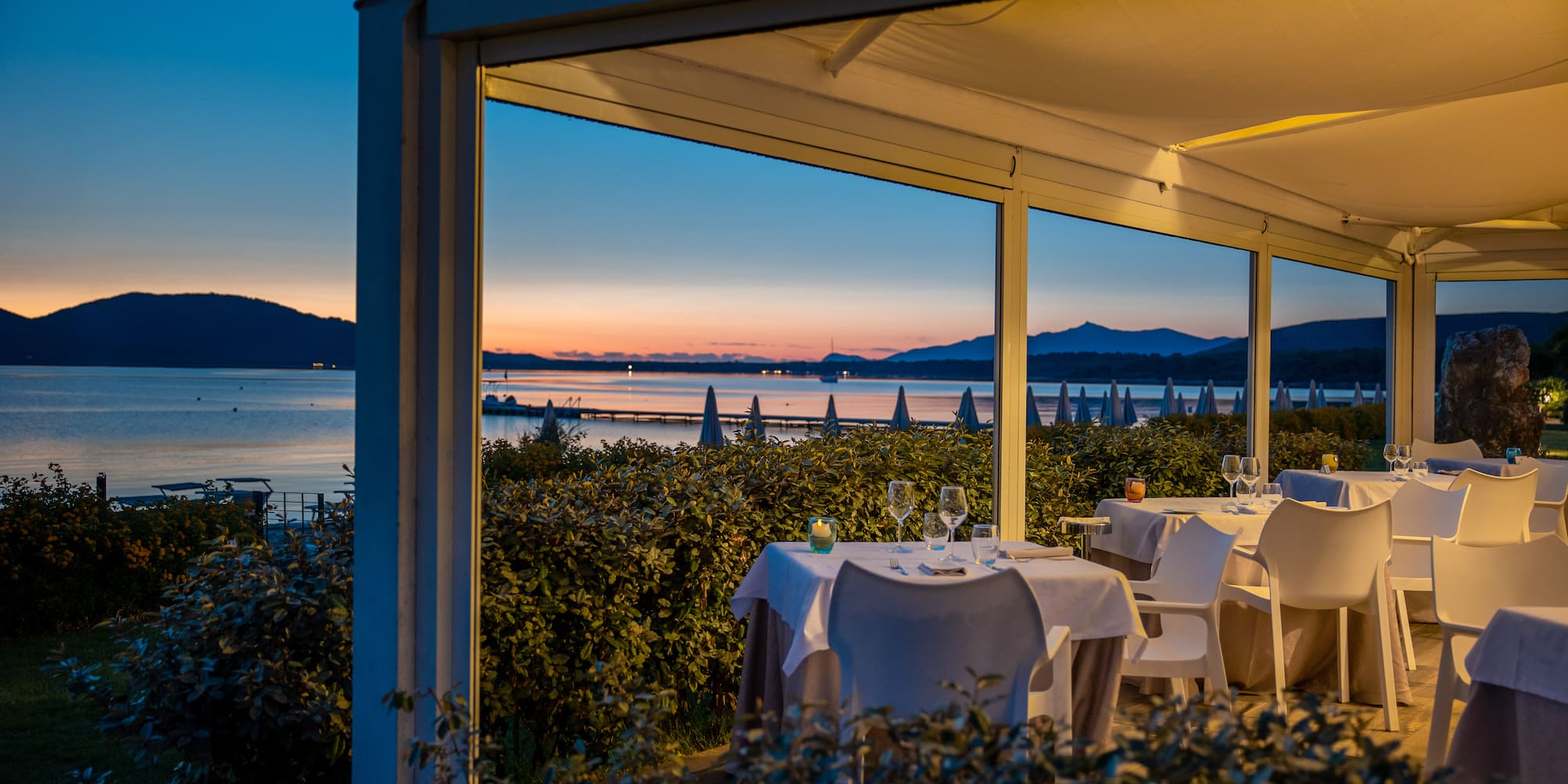 a table set up outside with a view of the ocean and mountains
